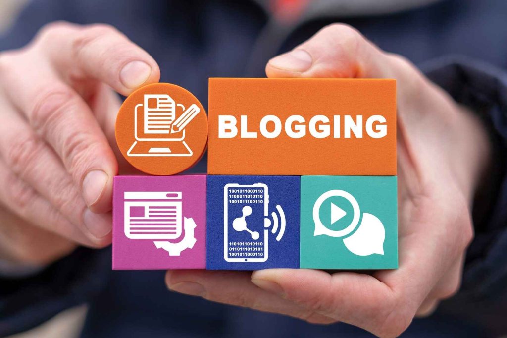 blog writing services - human hands holding colorful blocks with blogging word and symbols written on them